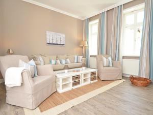 ein Wohnzimmer mit einem Sofa, 2 Stühlen und einem Tisch in der Unterkunft Villa Fernsicht - Apt. 04 in Ostseebad Sellin