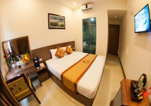 una camera d'albergo con letto e TV di La Paloma Hotel Ninh Binh a Ninh Binh