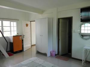 a bedroom with a bed and a closet and a door at Cottages @ Hill Resort in Mu Si