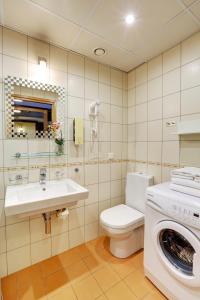 a bathroom with a toilet and a sink and a washing machine at Apartment24 - Foorum in Tallinn +14 photos