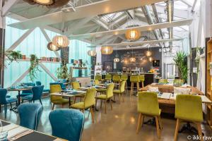 a restaurant with tables and chairs and a bar at Hotel Libera Spa et Restaurant Caen Colombelles in Caen