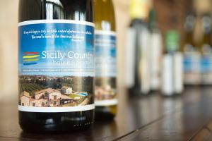 una bottiglia di vino seduta sopra un tavolo di Sicily Country House & Beach a Catania