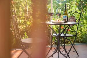 a table with two glasses of wine and a plate of food at Sicily Country House & Beach in Catania