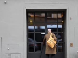a man walking out of a door with a bag at c-hotels Diplomat in Florence