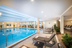 a swimming pool with tables and chairs in a building at Villa Abbazia - Liburnia in Opatija