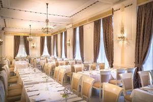 a restaurant with white tables and chairs and windows at Villa Abbazia - by Liburnia Hotels & Villas in Opatija +17 photos