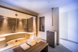 a bathroom with a shower and a bench with towels at Villa Abbazia - Liburnia in Opatija +17 photos