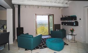 ein Wohnzimmer mit 2 blauen Stühlen und einem Balkon in der Unterkunft The Apartments Montone in Montone