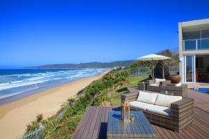 a patio with a couch and a beach at Dune Villa Wilderness in Wilderness