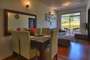 a living room with a dining room table and a couch at Vista Apartment Mariners Cabin in Nuwara Eliya