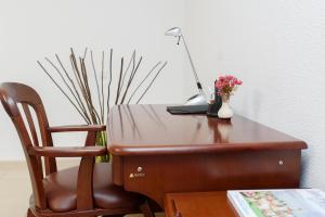 a wooden desk with a vase with a flower on top of it at M&M Aparthotel in Sumy