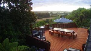 a wooden deck with a table and an umbrella at Hokitika Sunset Lodge in Hokitika