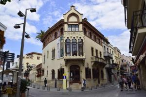 budynek na ulicy z ludźmi chodzącymi wokół niego w obiekcie Apartment Beach Front Canet w mieście Canet de Mar