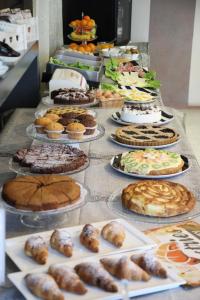 een buffet met veel verschillende soorten taarten en gebak bij Hotel Fidenza in Fidenza