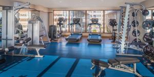 a gym with a blue floor and tread machines at Henann Crystal Sands Resort in Boracay