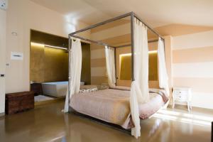 a bedroom with a canopy bed and a tub at Alessi Hotel Trattoria in Desenzano del Garda