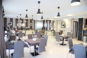 ein Restaurant mit Tischen und Stühlen in einem Raum in der Unterkunft Hotel Fidenza in Fidenza