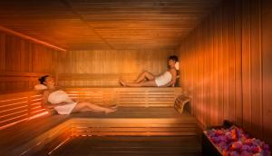 two people are sitting in a sauna at Hotel Imperial - Liburnia in Opatija