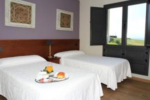 Habitación de hotel con 2 camas y bandeja de comida en Albergue Restaurante Casa Herminia en El Campiello