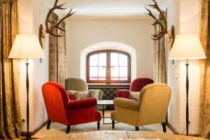 a waiting room with chairs and a table and a window at Schloss Prielau Hotel & Restaurants in Zell am See