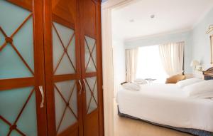 a bedroom with a bed and a dresser at Apartamentos Guadalpin Boutique in Marbella