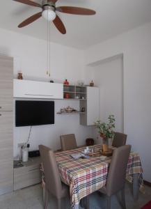 uma sala de jantar com uma mesa com cadeiras e uma ventoinha de tecto em Universal Apartments Itri em Itri
