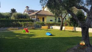 un cortile con due attrezzature per il parco giochi e un albero di La Chianarella ad Ascea