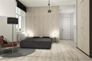 a bedroom with a bed and a chair and a television at De Pastorie in Middelkerke