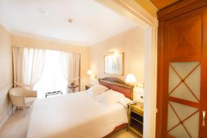 a hotel room with a white bed and a window at Apartamentos Guadalpin Boutique in Marbella +122 photos