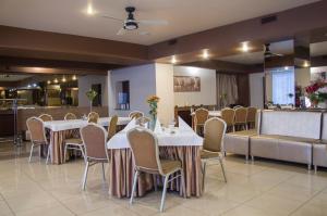 a dining room with white tables and chairs at euroHOTEL Katowice Nikiszowiec in Katowice