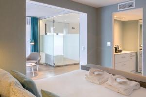 a bedroom with a mirror and a bed with towels at Van der Valk Hotel Saint-Aygulf in Saint-Aygulf