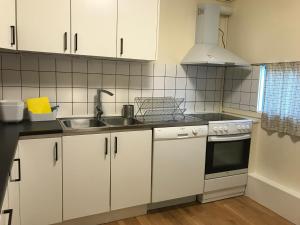 a kitchen with white cabinets and a sink at Apartments Ålholmvej in Copenhagen