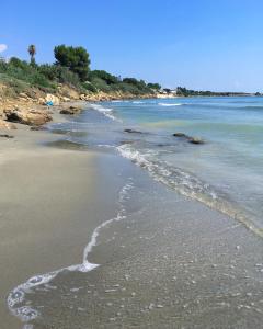 a beach with the tide coming in from the ocean at Birba Arya e Miele in Siracusa