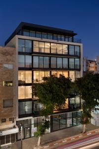 a tall building with windows in a city at Mr Allenby By TLV2GO in Tel Aviv