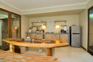 a kitchen with a wooden table and a refrigerator at Amara Giri I in Ubud