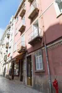 a pink building on a street with a red fire hydrant at Lisbon heart 1-cozy Flat-Family Friendly in Lisbon