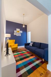 a living room with a blue couch and a yellow chair at Lisbon heart 1-cozy Flat-Family Friendly in Lisbon