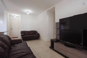 a living room with a couch and a flat screen tv at Apartamento Lopes em Cabo Frio in Cabo Frio