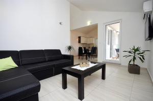 a living room with a black couch and a table at Ljiljana in Srima