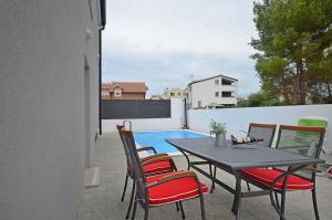 a patio with a table and chairs and a pool at Ljiljana in Srima