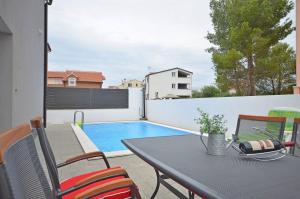 a patio with a table and chairs and a swimming pool at Ljiljana in Srima