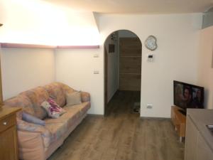 uma sala de estar com um sofá e um relógio na parede em Casa Litegosa em Panchia