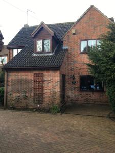 a red brick house with a brick driveway at Simpson's Apartments in Daventry