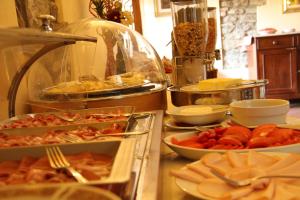 een buffet met veel verschillende soorten eten op een aanrecht bij Villa Rigacci Hotel in Reggello