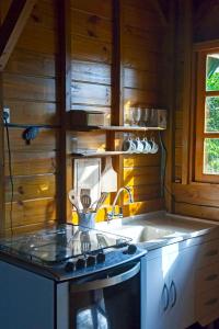 uma cozinha com um fogão e um lavatório em Pousada Moradas do Moçambique em Florianópolis mais 51 fotografias