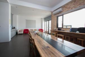 uma sala de aula com uma longa mesa e cadeiras de madeira em Travelers Hostel em Magong