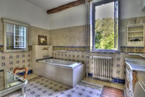 a bathroom with a tub and a sink and a window at Château De Blavou Normandie in Saint-Denis-sur-Huisne