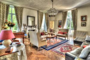 sala de estar con muebles y lámpara de araña. en Château De Blavou Normandie en Saint-Denis-sur-Huisne