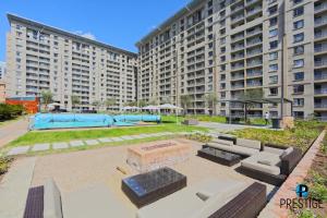 a large apartment building with a patio in front of it at Prestige Apartments Sandton at Westpoint in Johannesburg