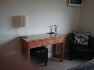 
a living room with a desk and a lamp at Shangri-la bed and breakfast in Leuchars
